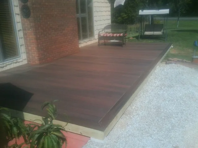 Freshly stained wood deck built against a brick home in Morton